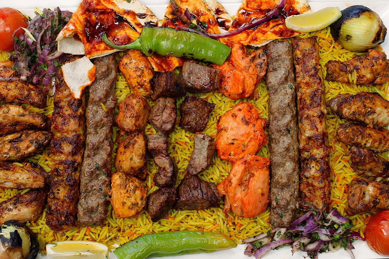 Mixed grill platter on charcoal with beef and chicken skewers, wings and rice at Donya Kebab in London, Ontario